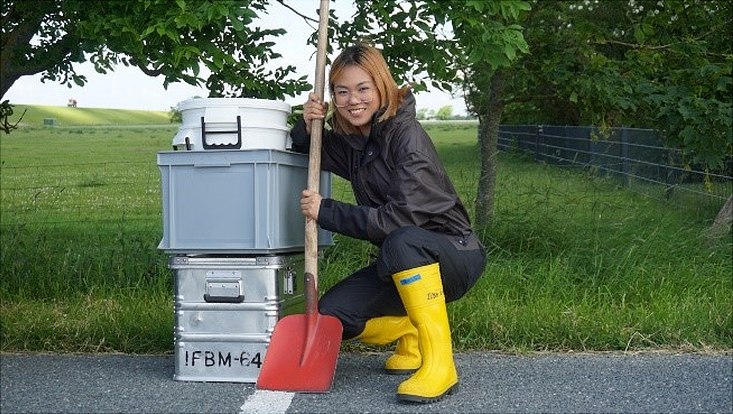Photo of Panunporn Tutiyasarn in yellow gumboots and with a red shovel.